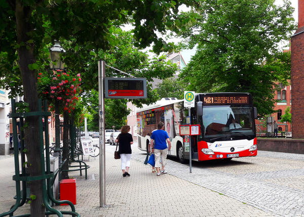 UVG Bus hält an einer Haltestelle, Fahrgäste steigen zu